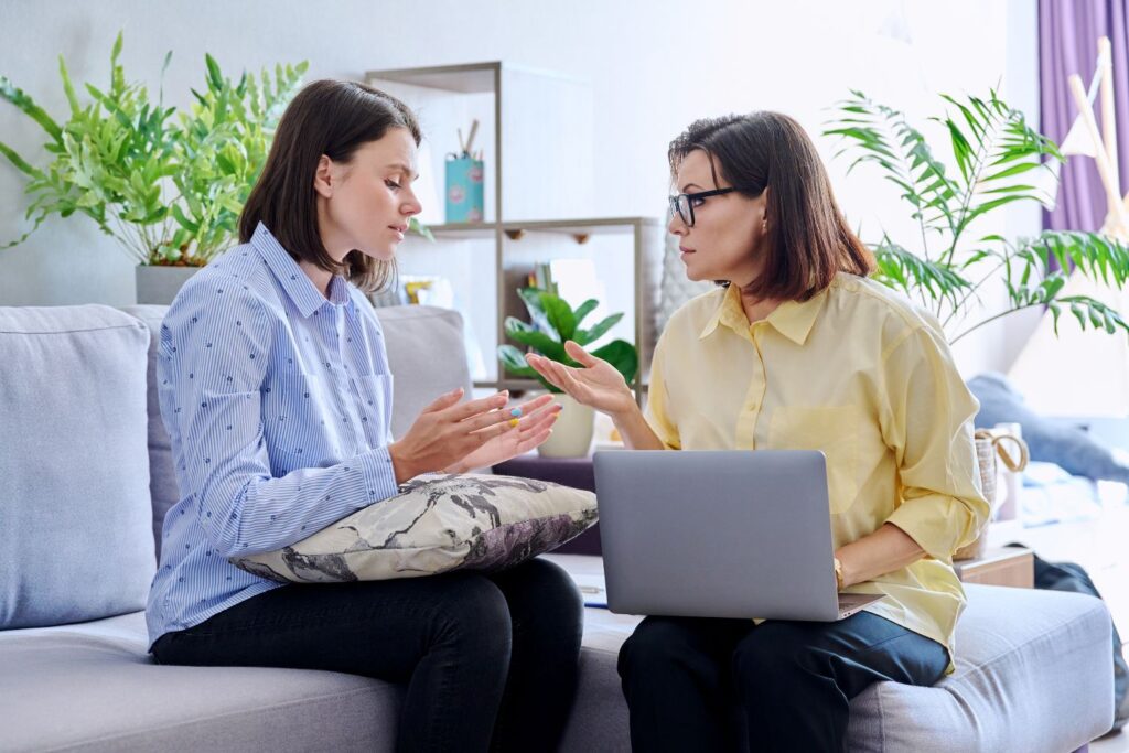 Young woman patient on individual therapy in psychologists office Mature female counselor listening taking notes talking Psychology psychiatry treatment mental health concept